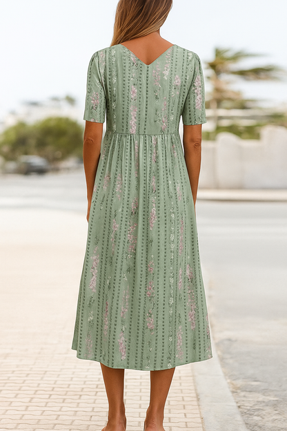 Woman wearing elegant botanical print midi dress with A-line silhouette and leafy green pattern